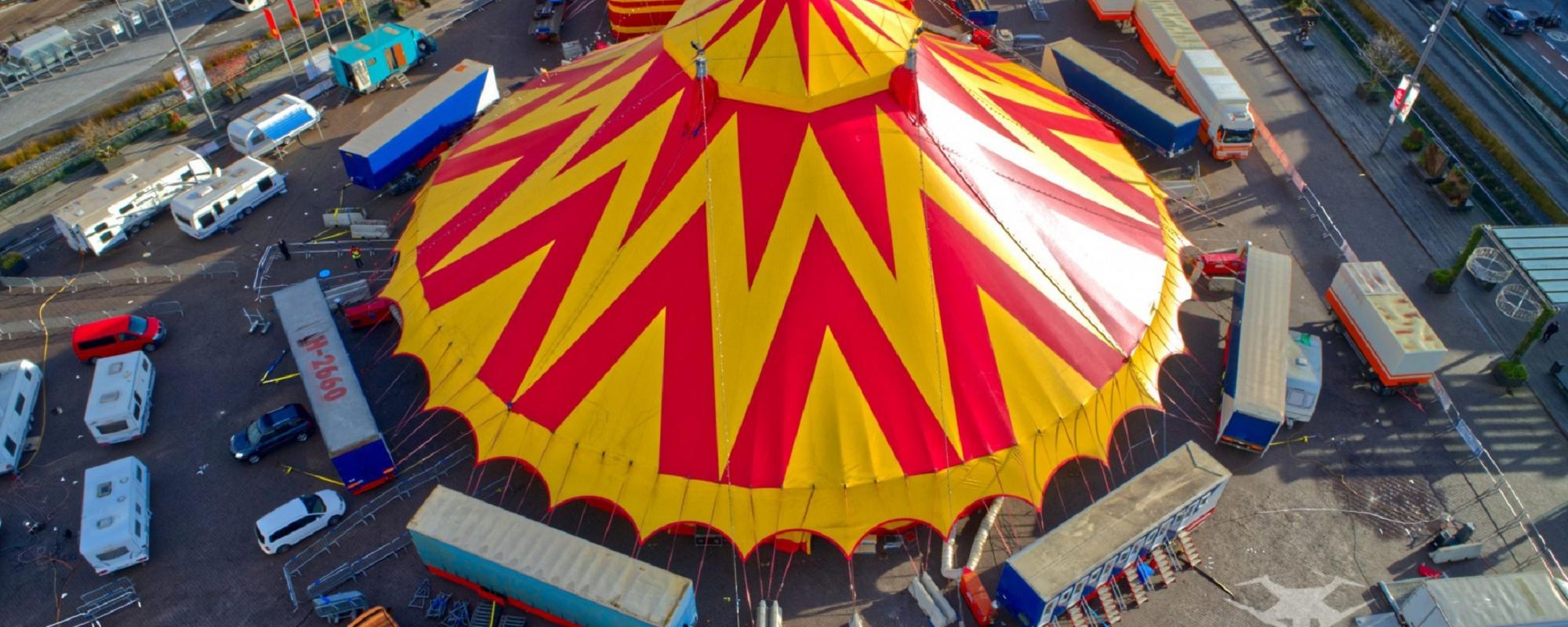 Luchtfoto van het circusdorp van Sint in de Piste met centraal de rood-gele circustent en daarrond circuswagens