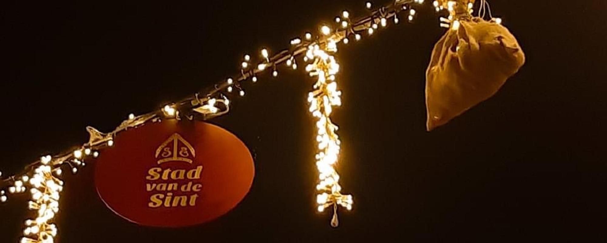 Sinterklaasversiering aan een slinger met lichtjes tegen de donkere avondhemel